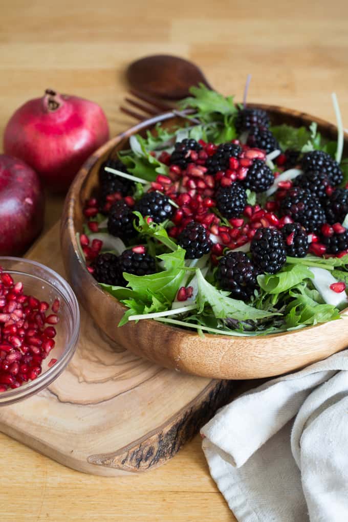 Berry salad with red onions, arugula, nuts and pomegranate arils