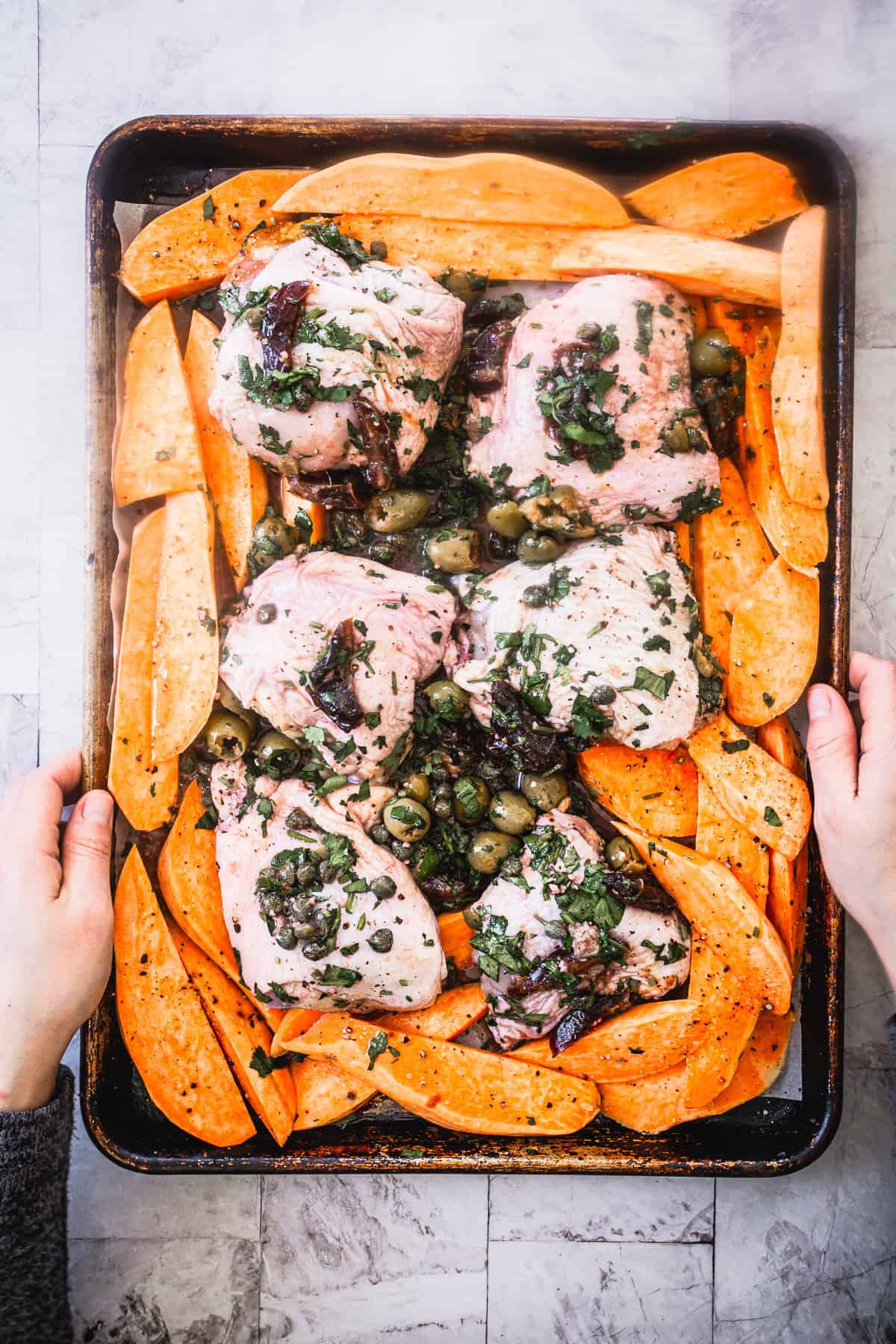 placing chicken marbella ottolenghi tray in the oven