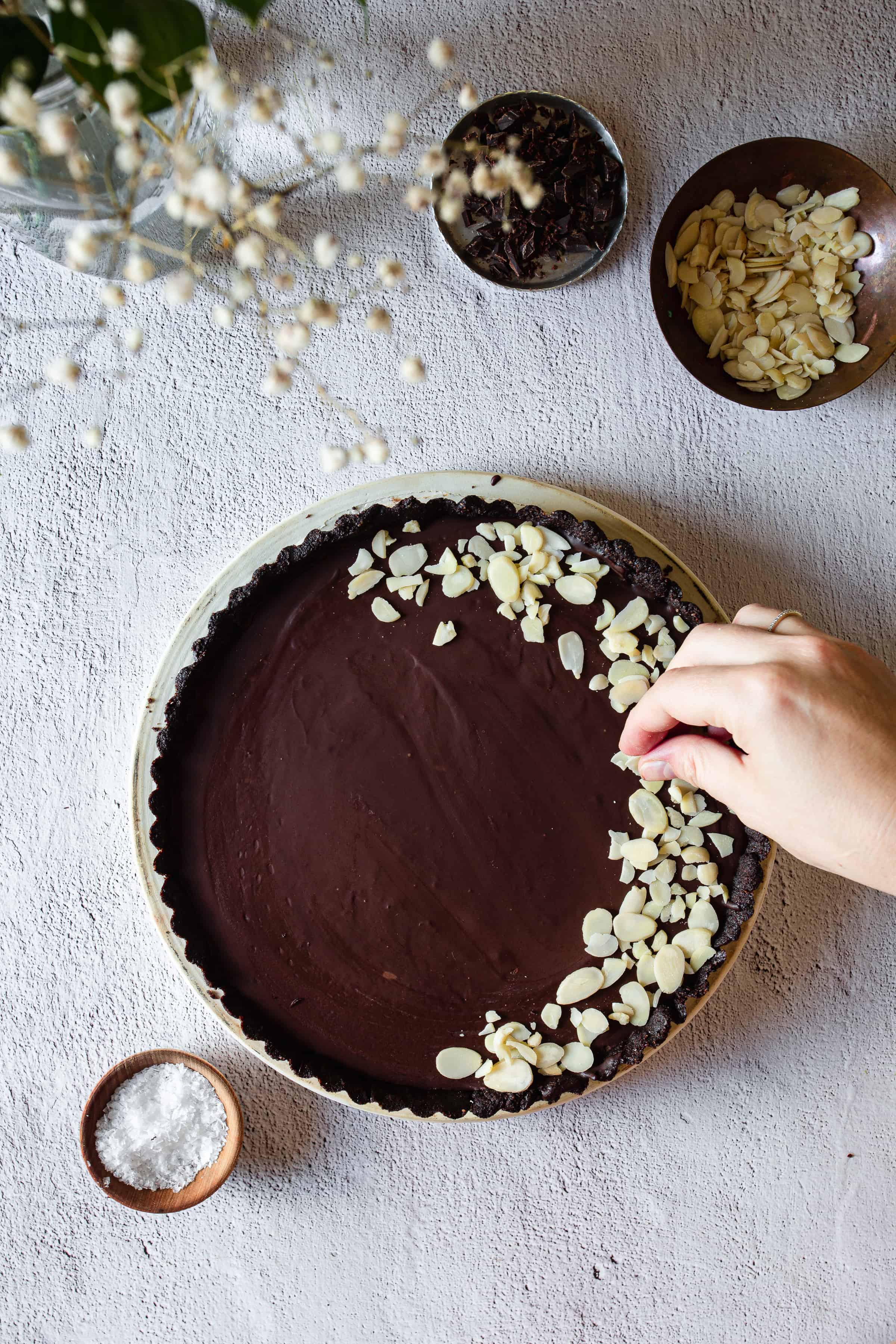 arranging almonds on chocolate tart
