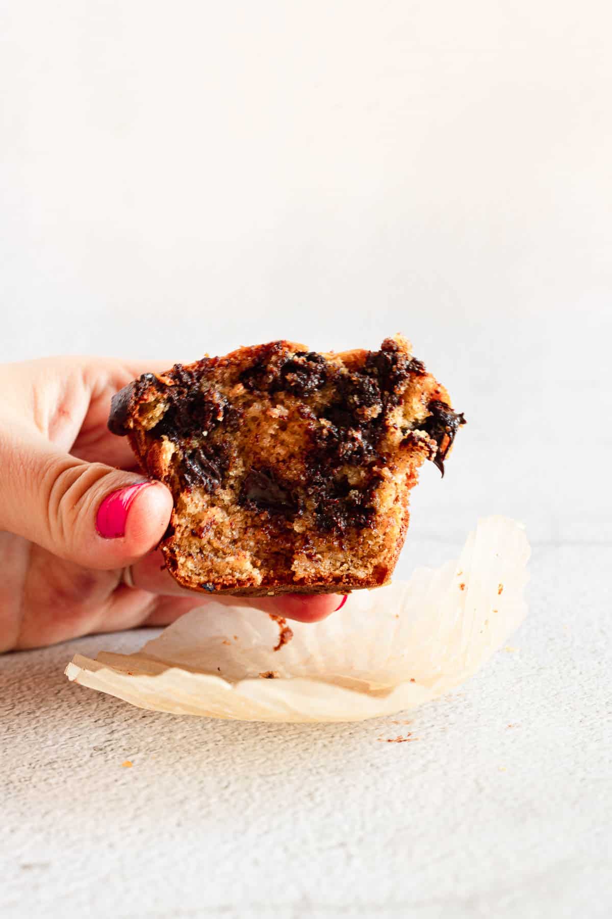 hand holding gluten free chocolate chip muffin half