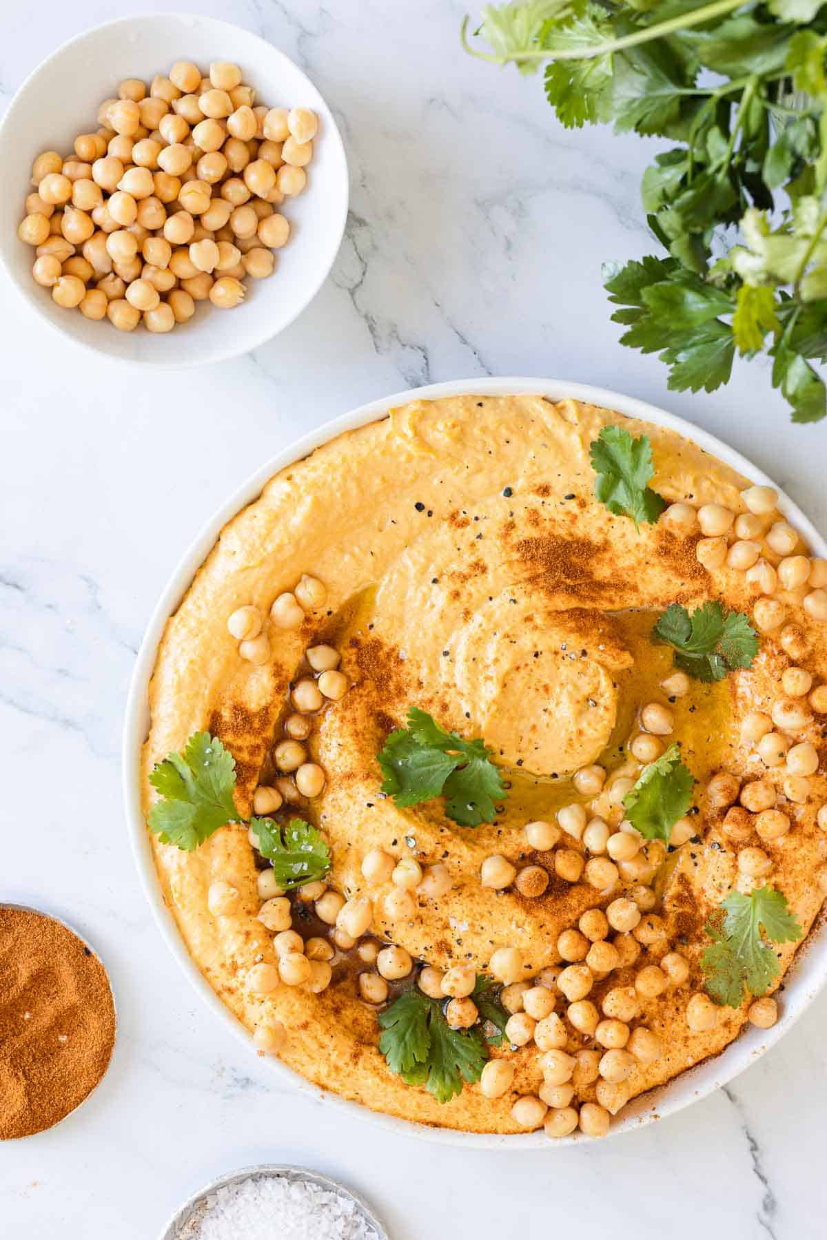 Overhead view of a freshly garnished dish of sweet potato hummus.